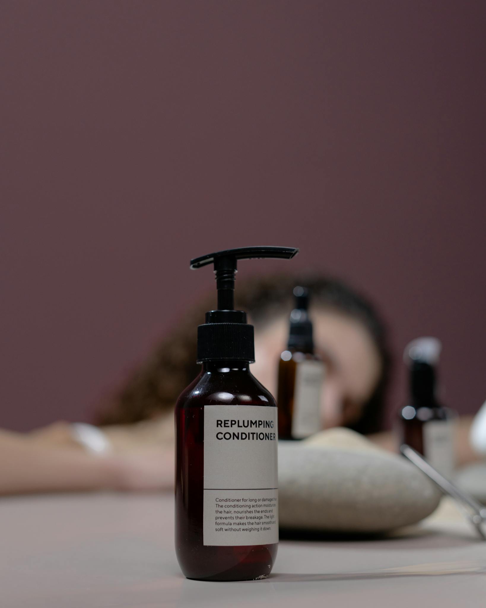 Elegant studio shot of an organic replumping conditioner with focus on the bottle.