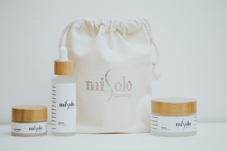 Minimalist photo of organic skincare products with bamboo lids and a canvas bag on a white background.